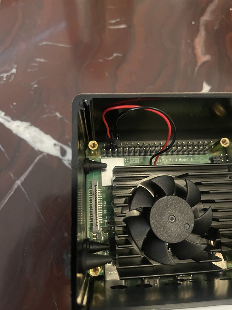 Close-up of the red and black fan wires connected to the GPIO header, sitting next to each other just after the first pin